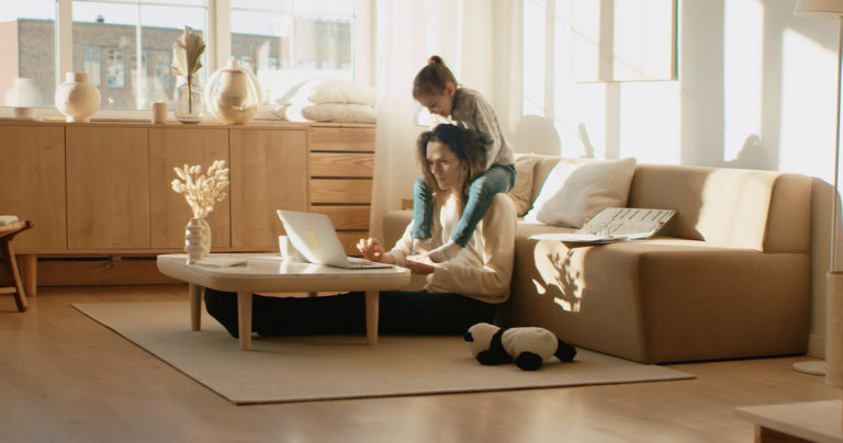 Mother working from home, her daughter distracts her and drawing attention
